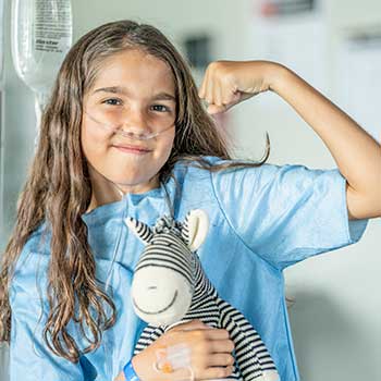 Young girl in hospital holding stuffed animal