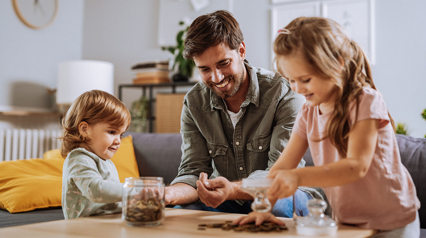 father and two young daughters counting change