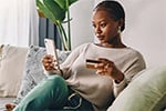 woman sitting on couch looking at phone