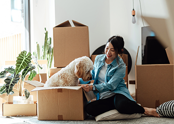woman unpacking a box with her dog