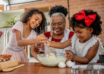 grandmother baking with two grandchildren