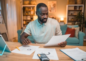 man sitting at desk looking at paperwork