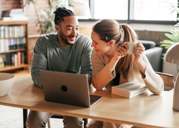 woman and man discussing expenses in front of a laptop