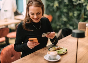 woman paying on her smartphone with credit card