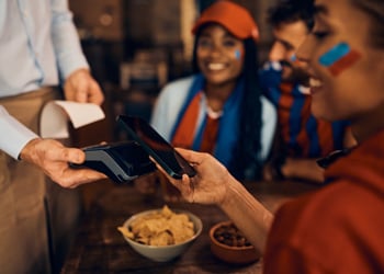 woman tapping her smartphone to make a purchase