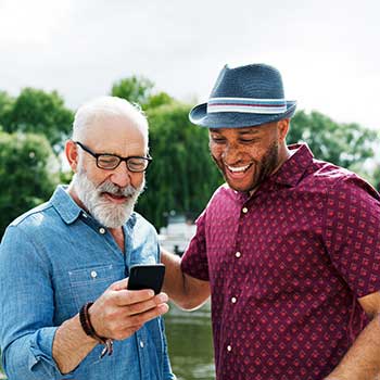 two men smiling and looking at phone