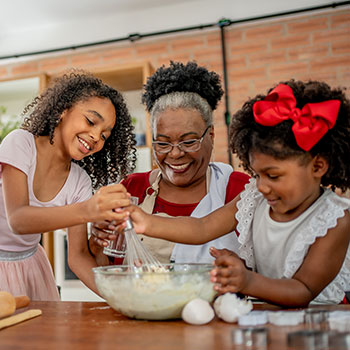 grandmother and two young children holiday baking