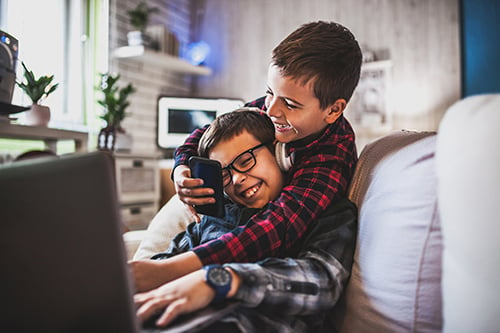 young brothers playing on laptop